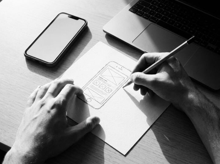 Designer sketching a mobile app wireframe on paper